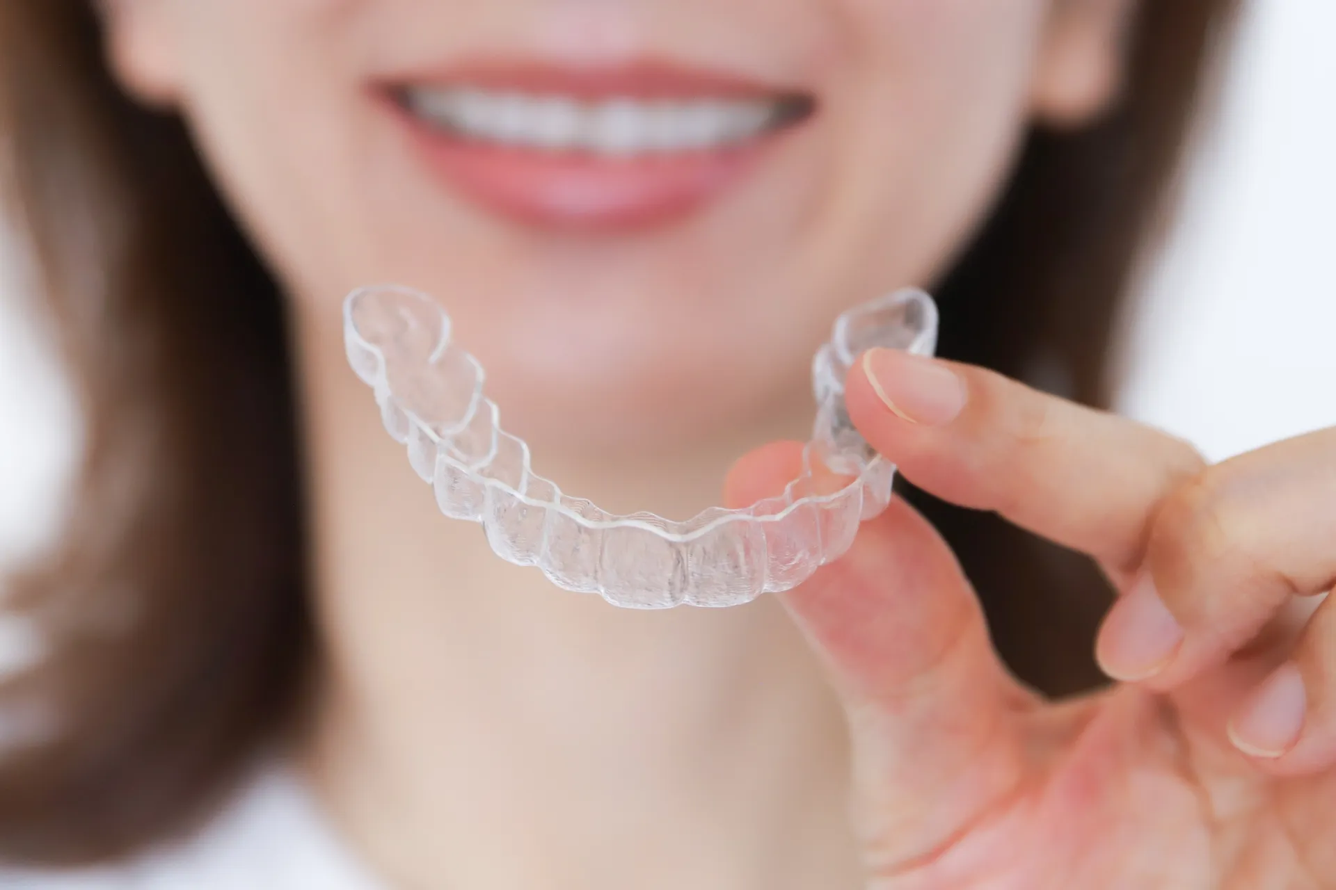 家でマウスピースを付けようとする女性の画像