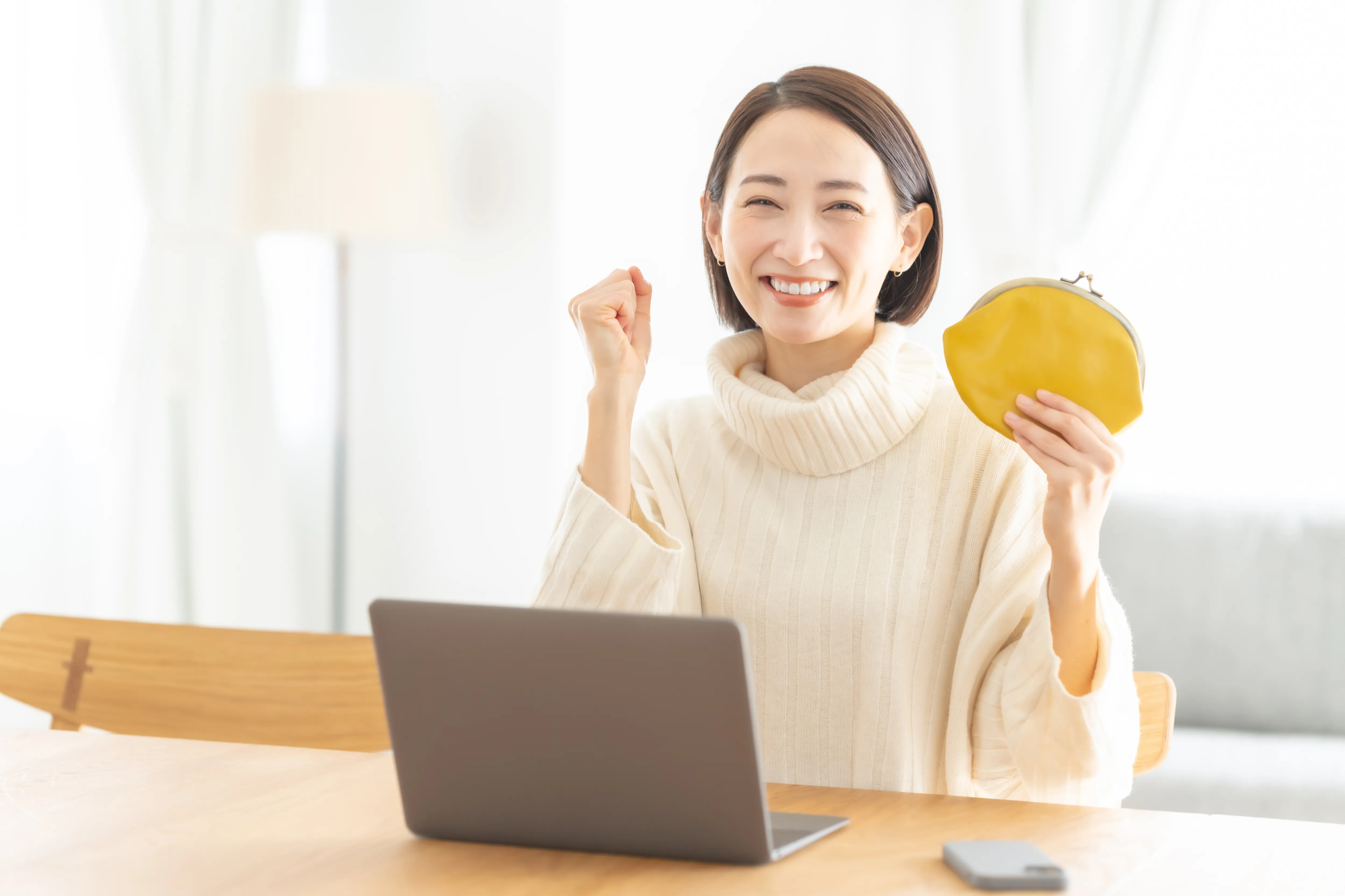 財布を持った笑顔の女性の画像
